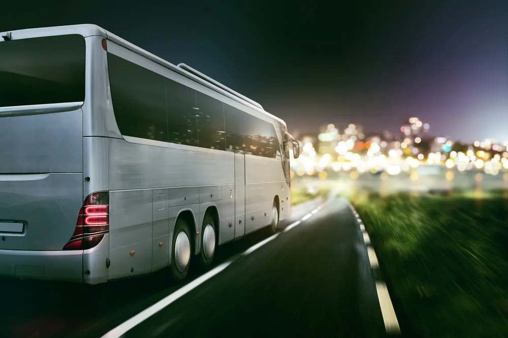 Shuttle bus lit at night outside Brisbane Airport, ready for a Hervey Bay airport transfer