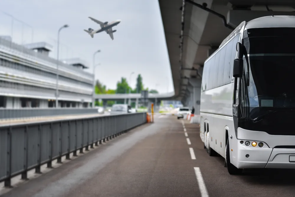 Large white shuttle bus waiting at the Brisbane airport terminal for the return trip to Hervey Bay