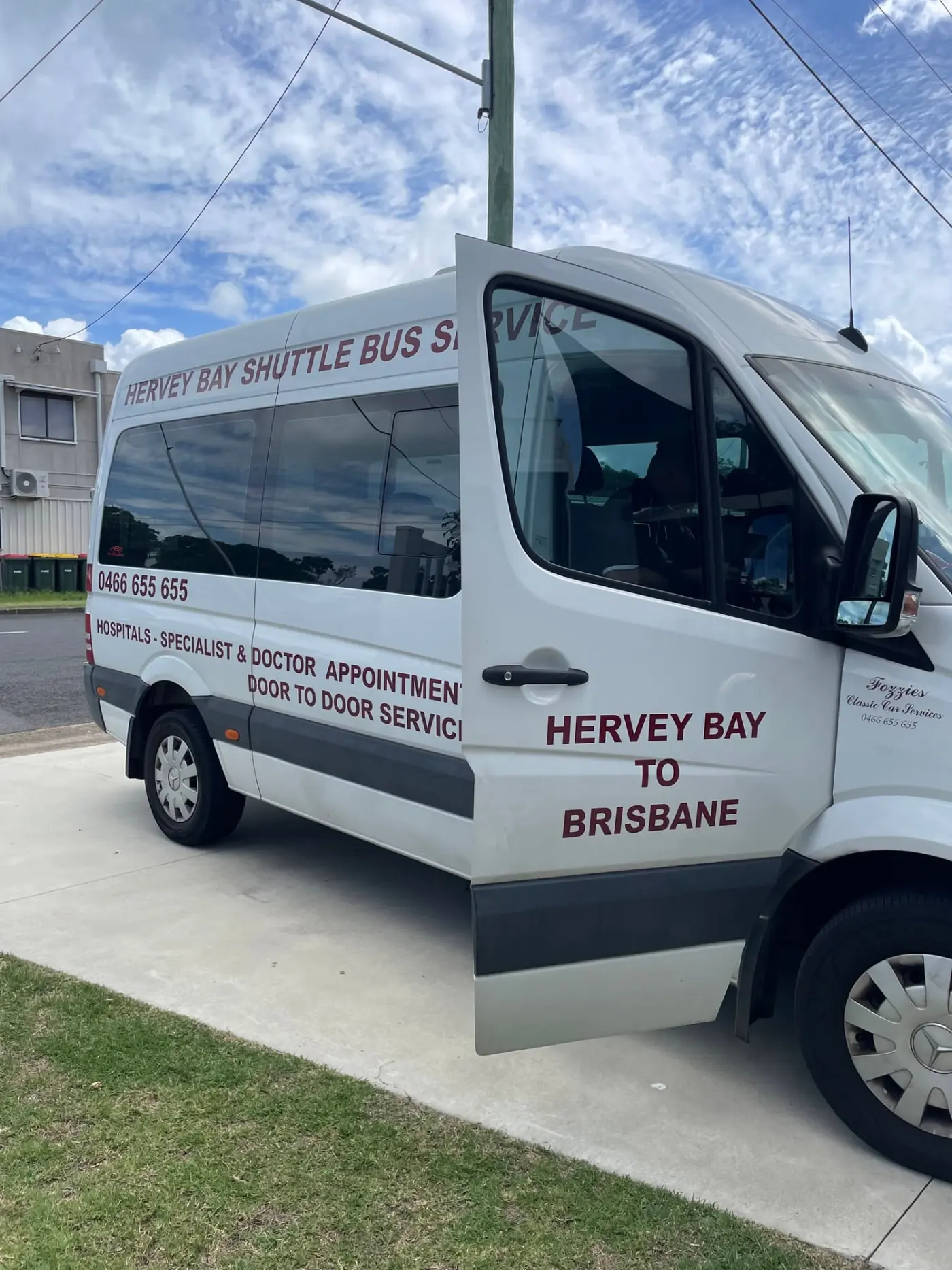 White shuttle van on the Bruce Highway heading from Hervey Bay to Brisbane with passengers aboard